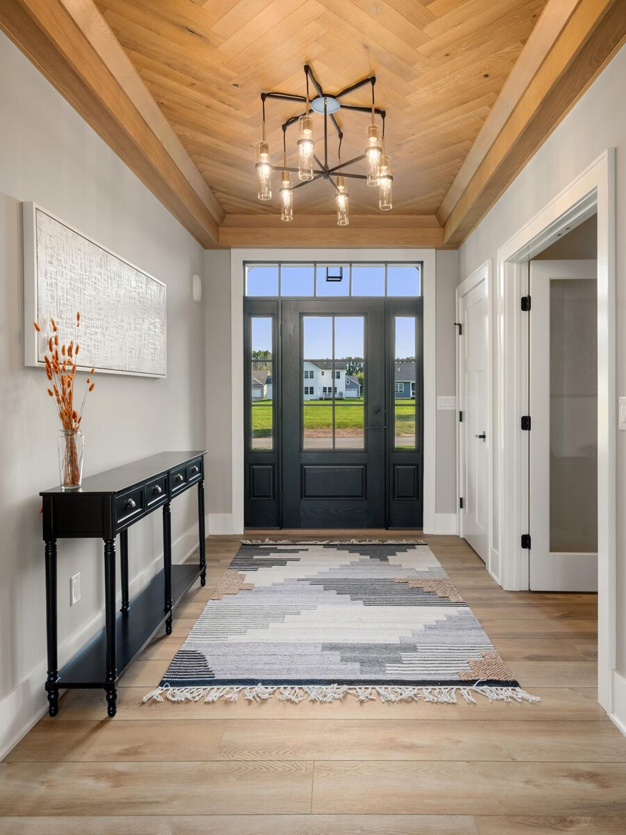 Foyer with a wood plank ceiling, chandelier and a glass-paneled front door